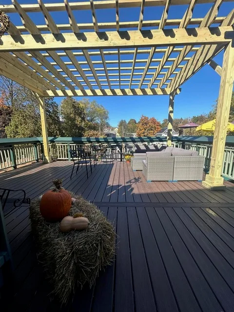 Composite deck with attached pergola, white railings, and outdoor furniture