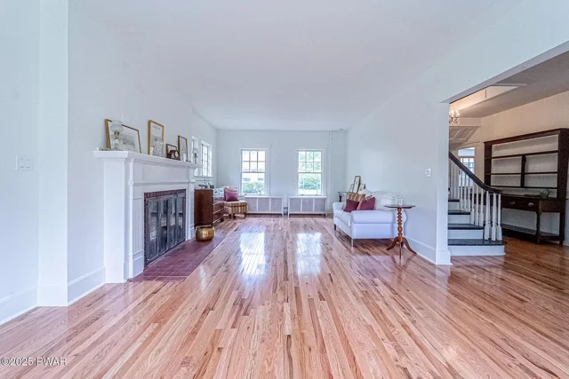 Hardwood flooring installation in open living room with fireplace and natural light