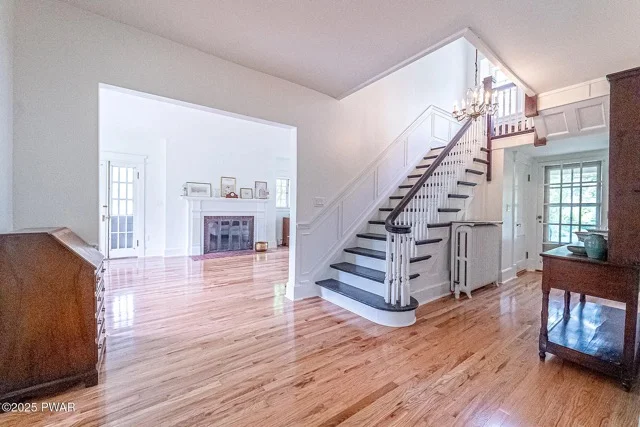 Hardwood flooring installation in open living area with staircase and white trim